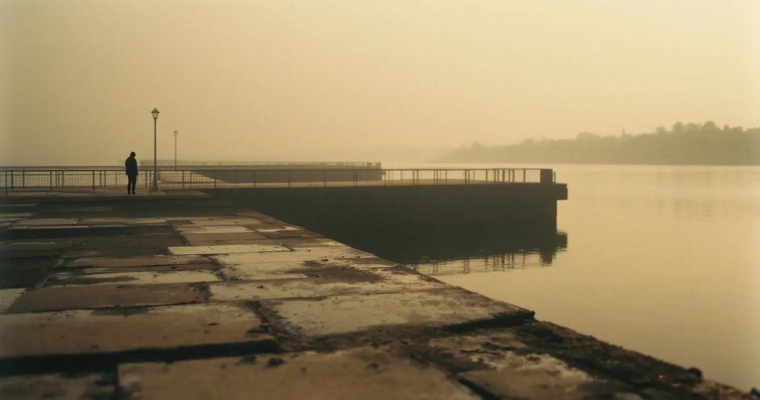 Still bay water at dawn past a low seawall