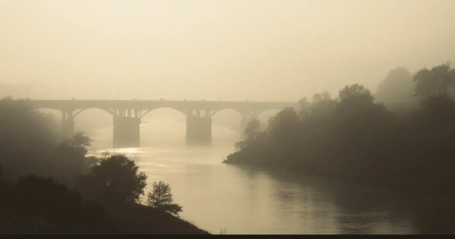 Distant river crossing seen through soft haze at first light